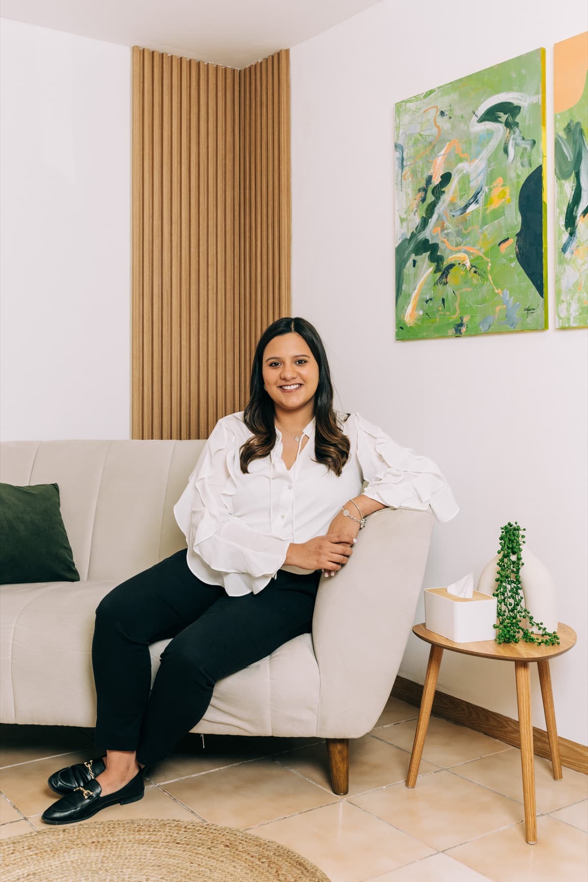 Psicóloga en San Salvador sentada en un sillón durante una sesión en Mood Clinic, mostrando una expresión cálida y profesional.